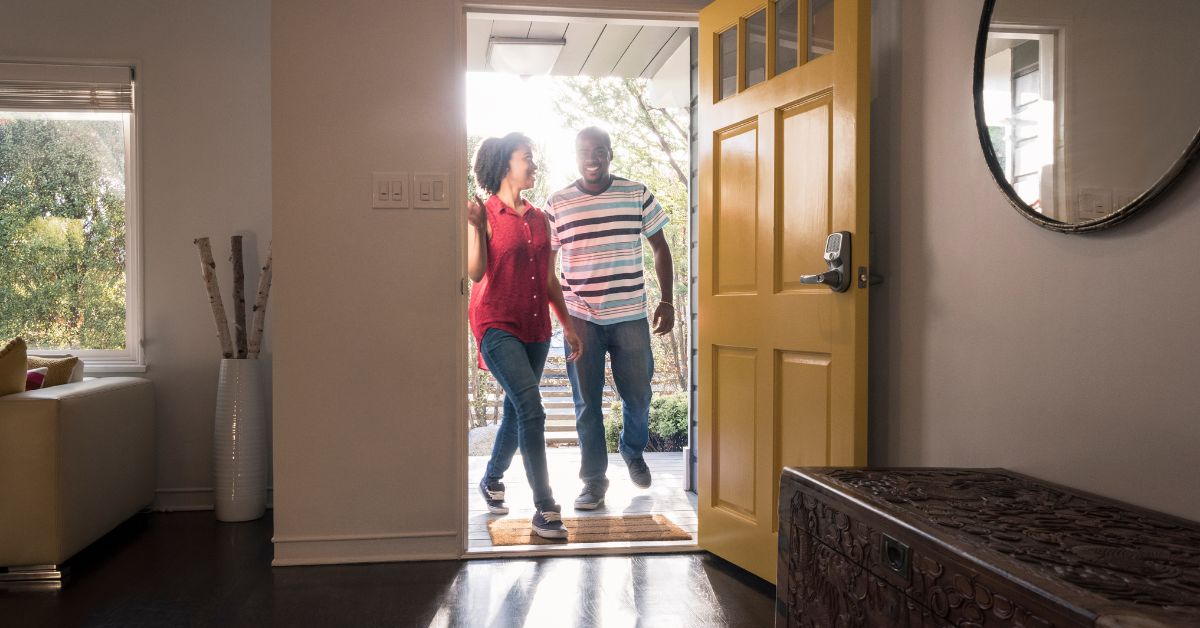 Couple walking in the front door of their home